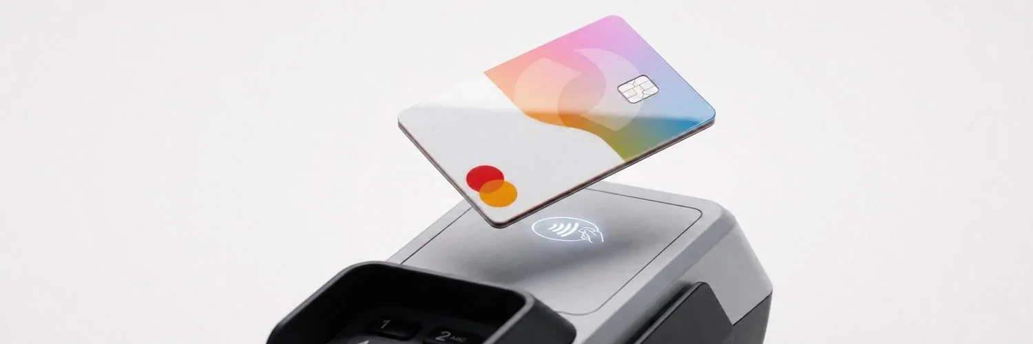 Carte aux couleurs pastel au-dessus d’un terminal de paiement sans contact.